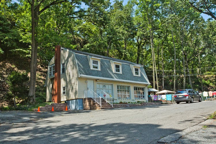 Building with dormer windows and a car on a road