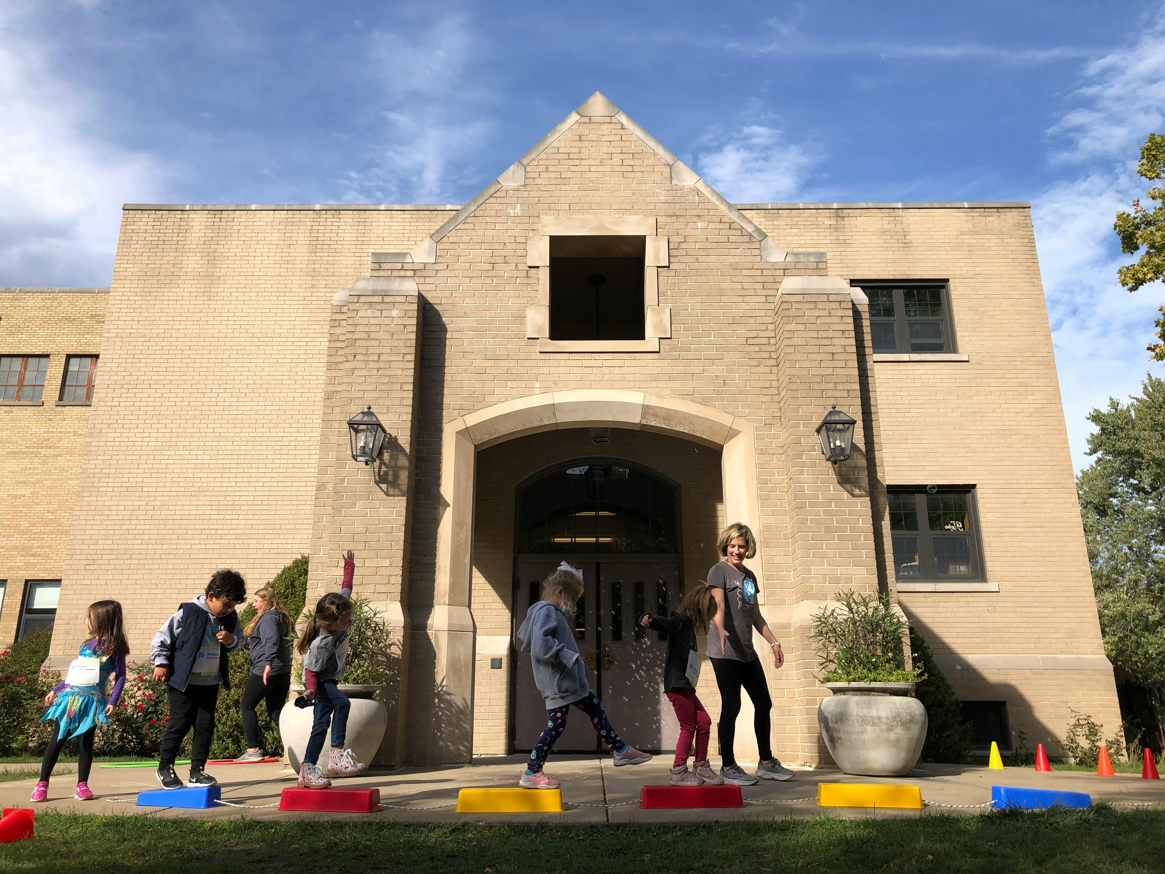 Children playing on colorful blocks in front of a building