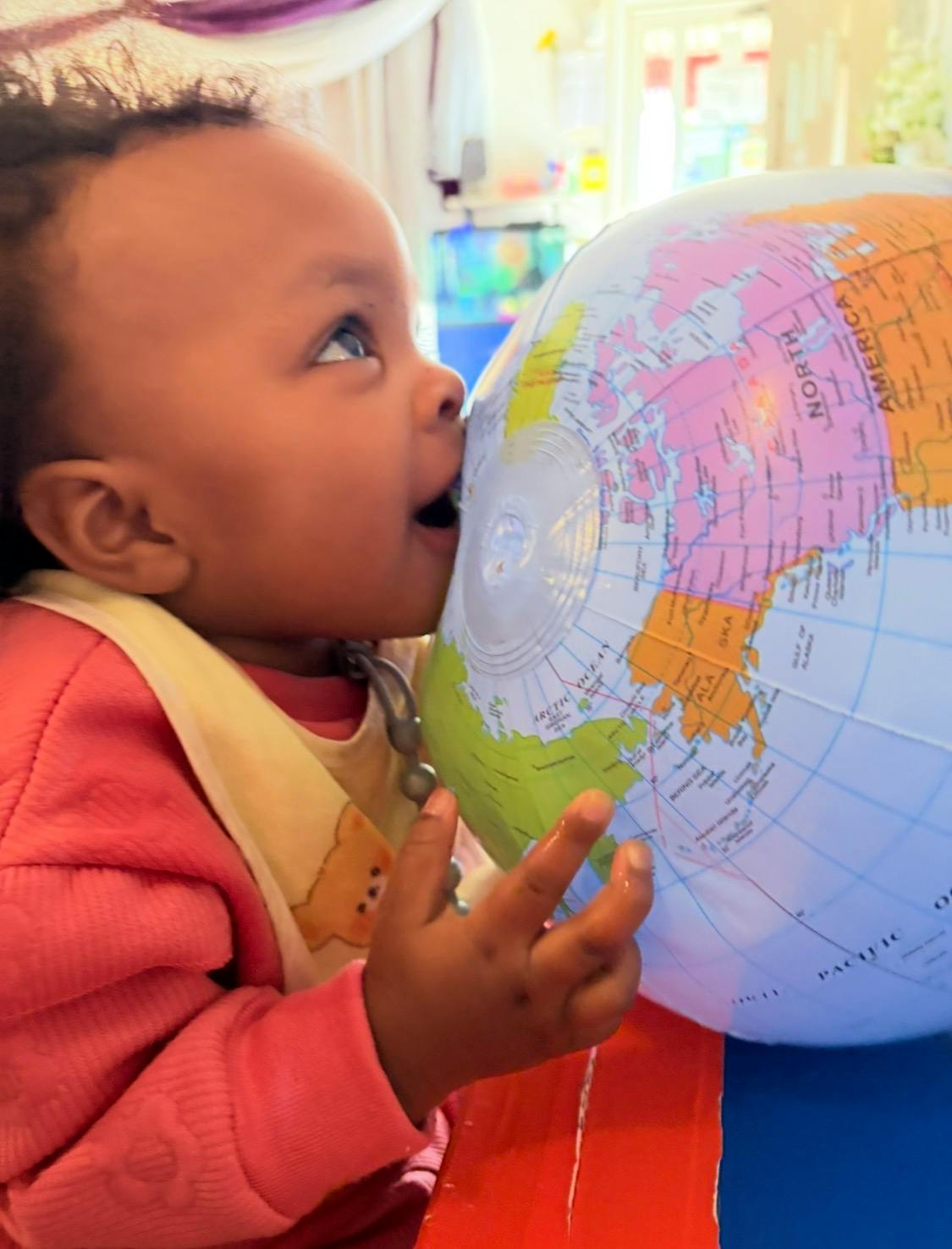 Child playing with an inflatable globe
