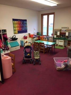 Playroom with strollers, tables, and toys