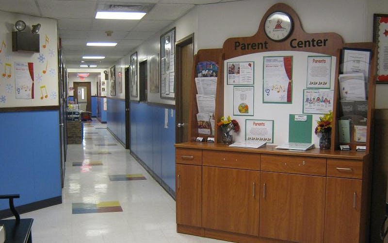 A school hallway with a wooden parent center kiosk