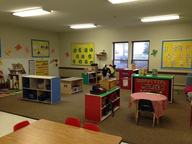 An empty classroom with various learning stations and colorful bulletin boards