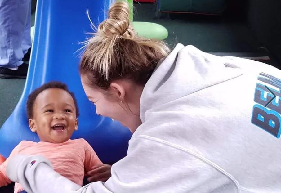 Person in white hoodie looking at a child