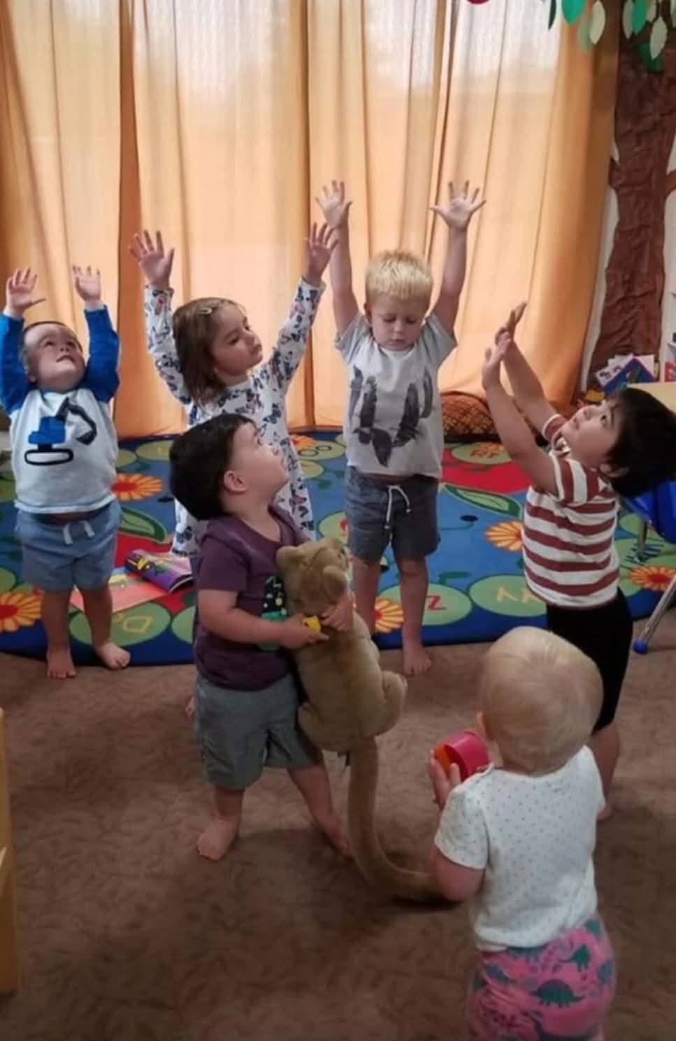 Children with hands raised in a classroom