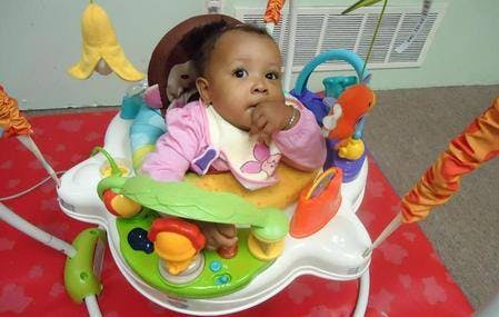 Child in a baby bouncer with toys
