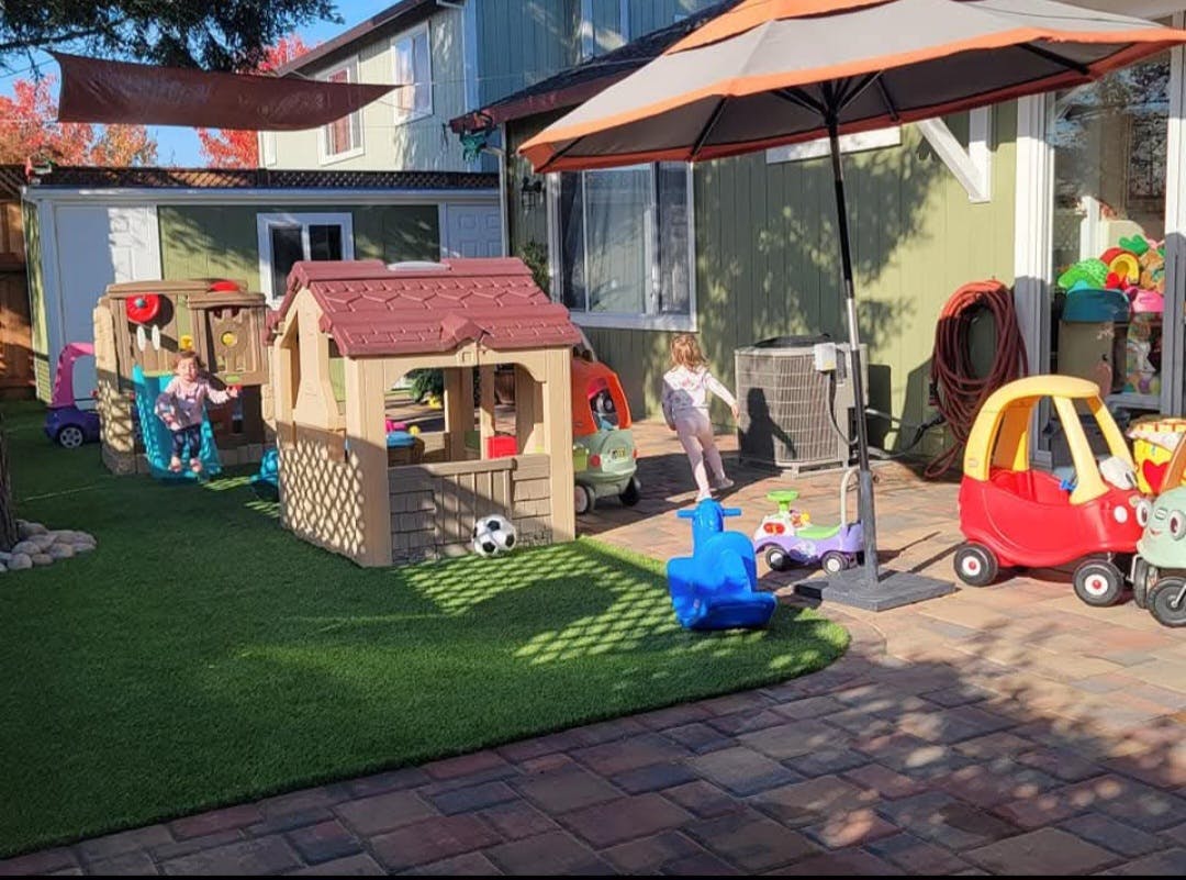 Children playing with plastic toys in a residential backyard