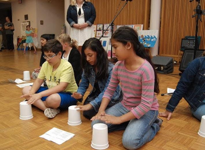 Children sitting on floor playing with cups