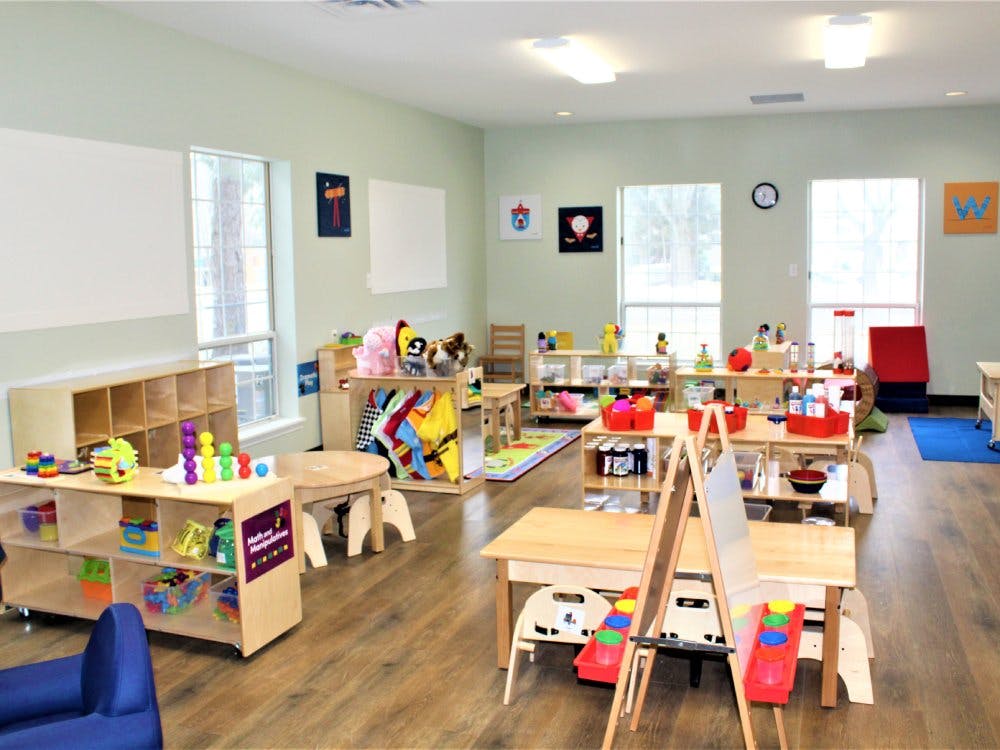 Classroom filled with small tables, chairs, and learning materials