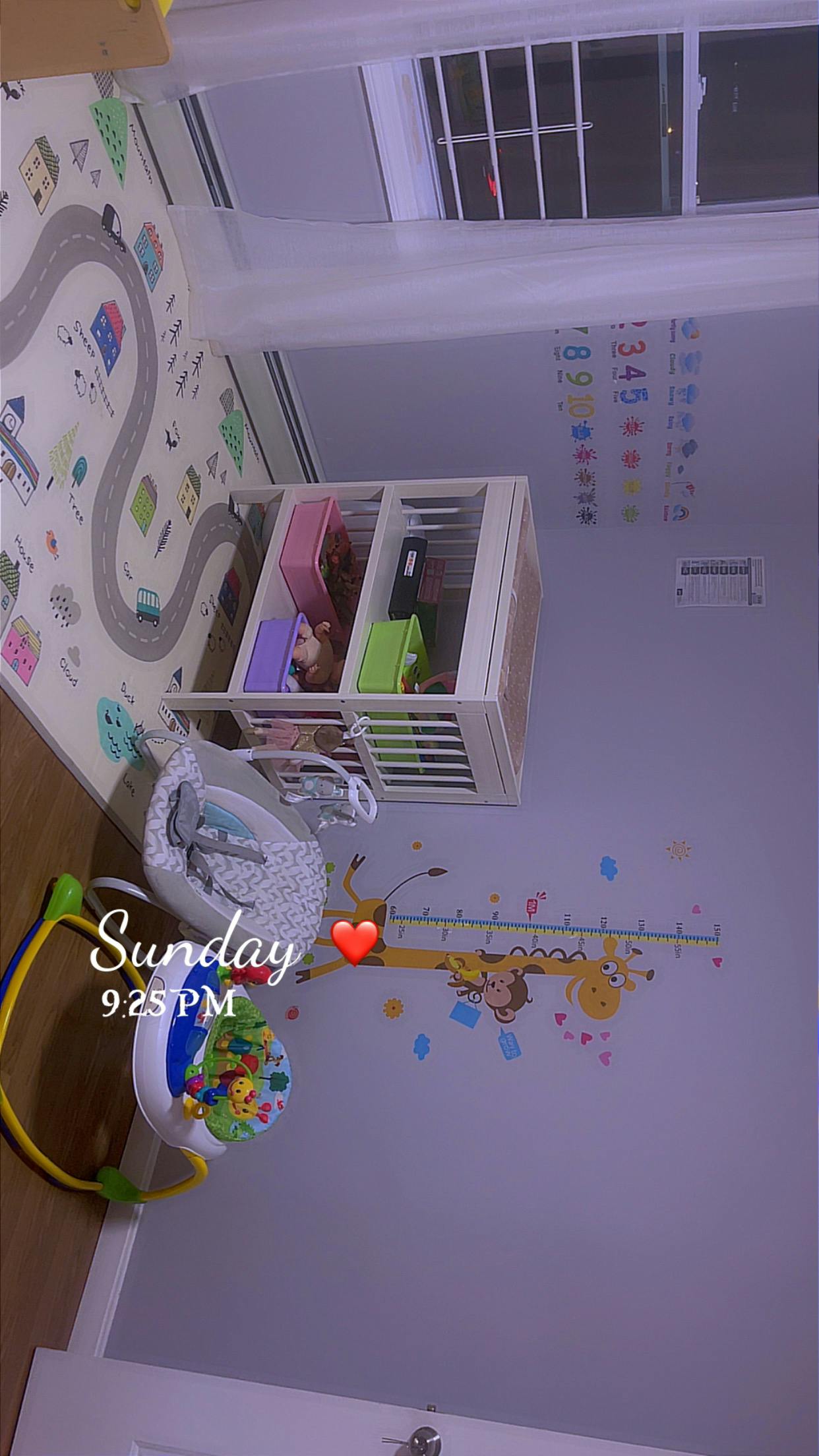 Nursery room with a crib, play mat, and baby bouncer