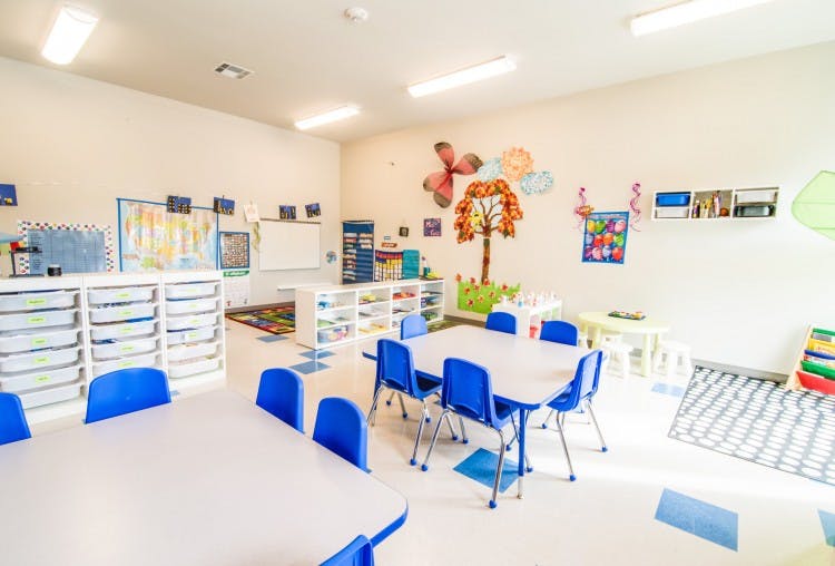 Empty classroom with small tables and blue chairs