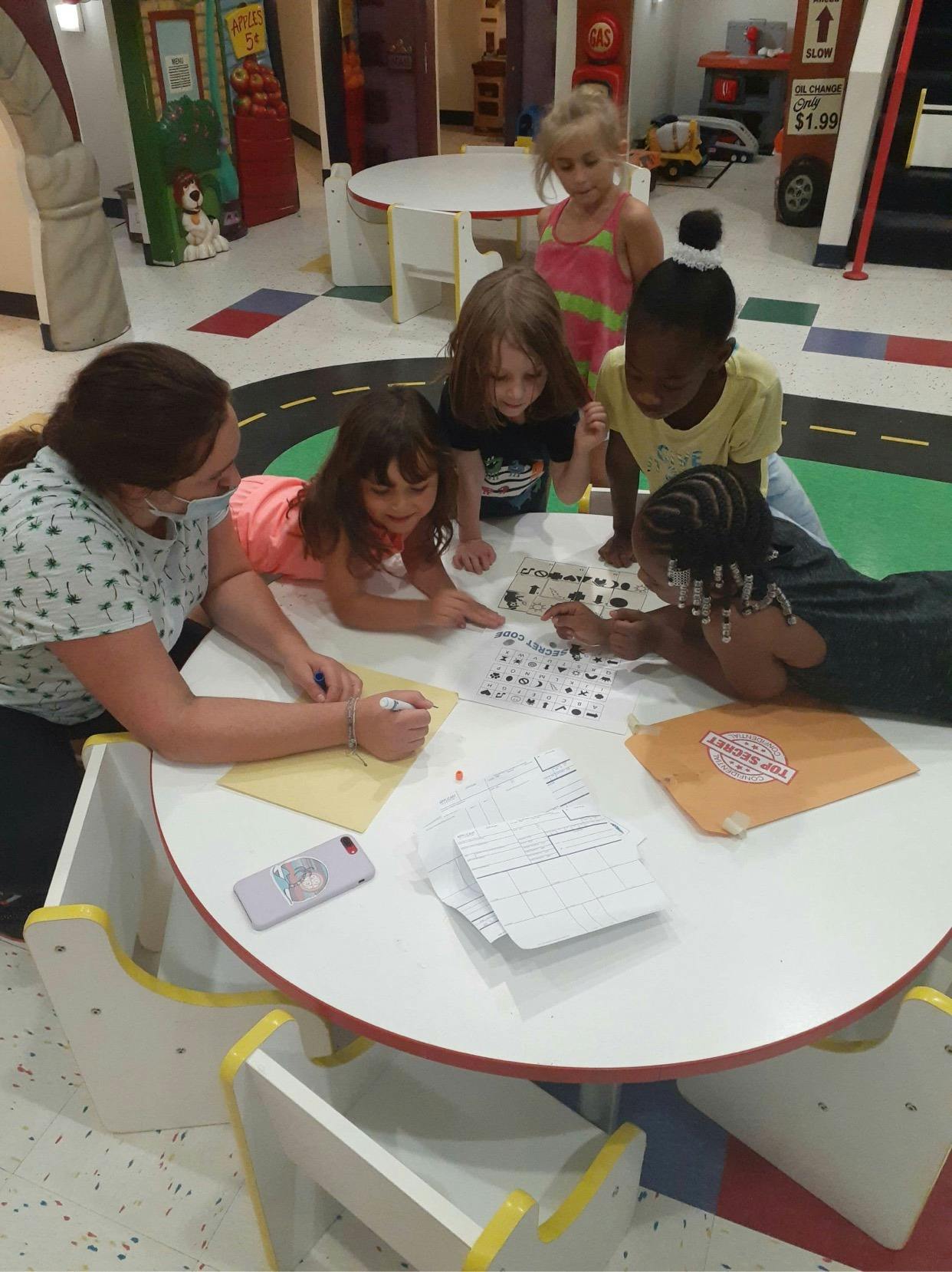 Adult and children gathered around a table, looking at papers