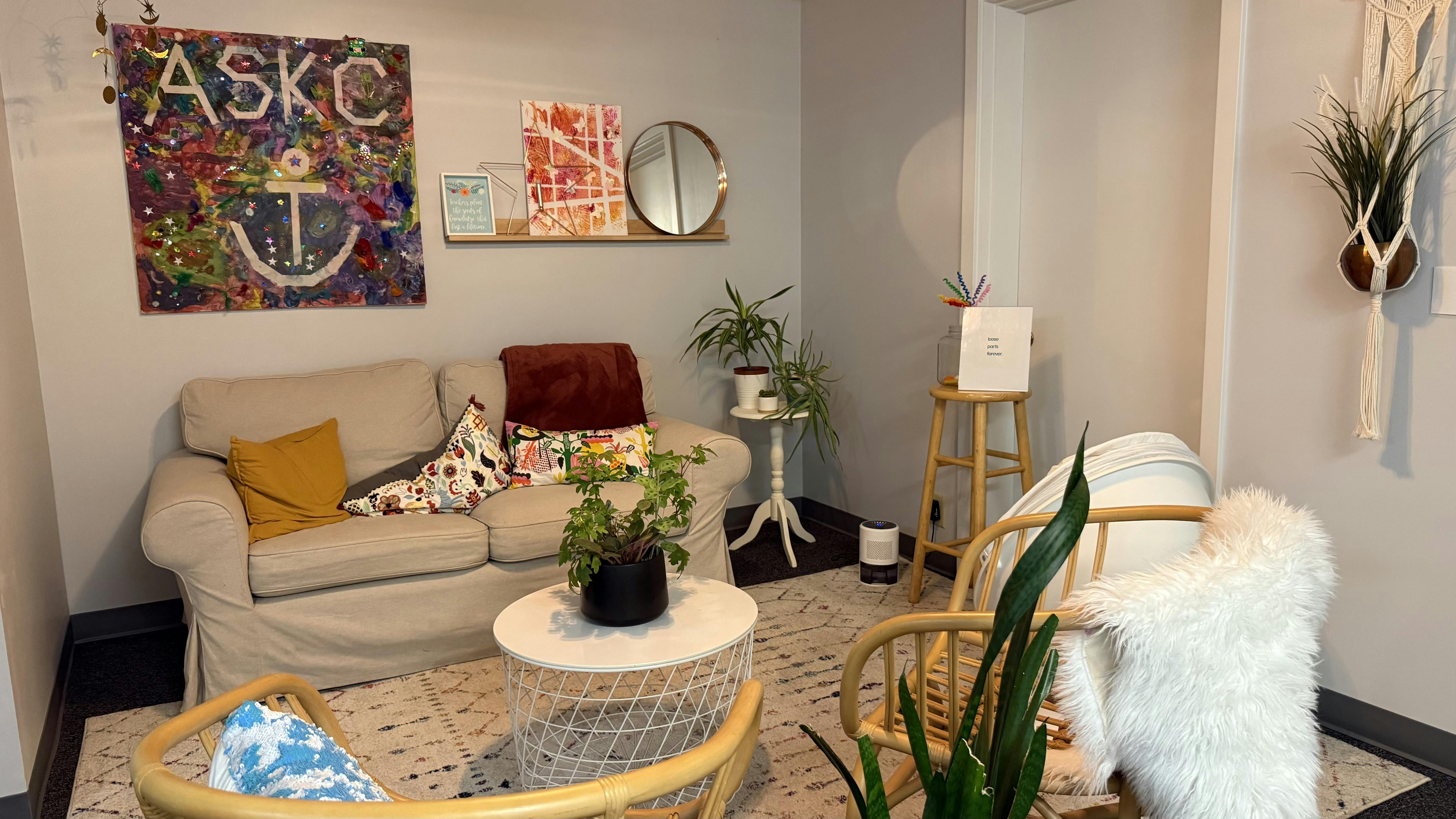 Living room with a couch, chairs, and plants