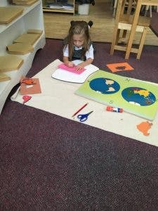 Child working on a craft project on the floor