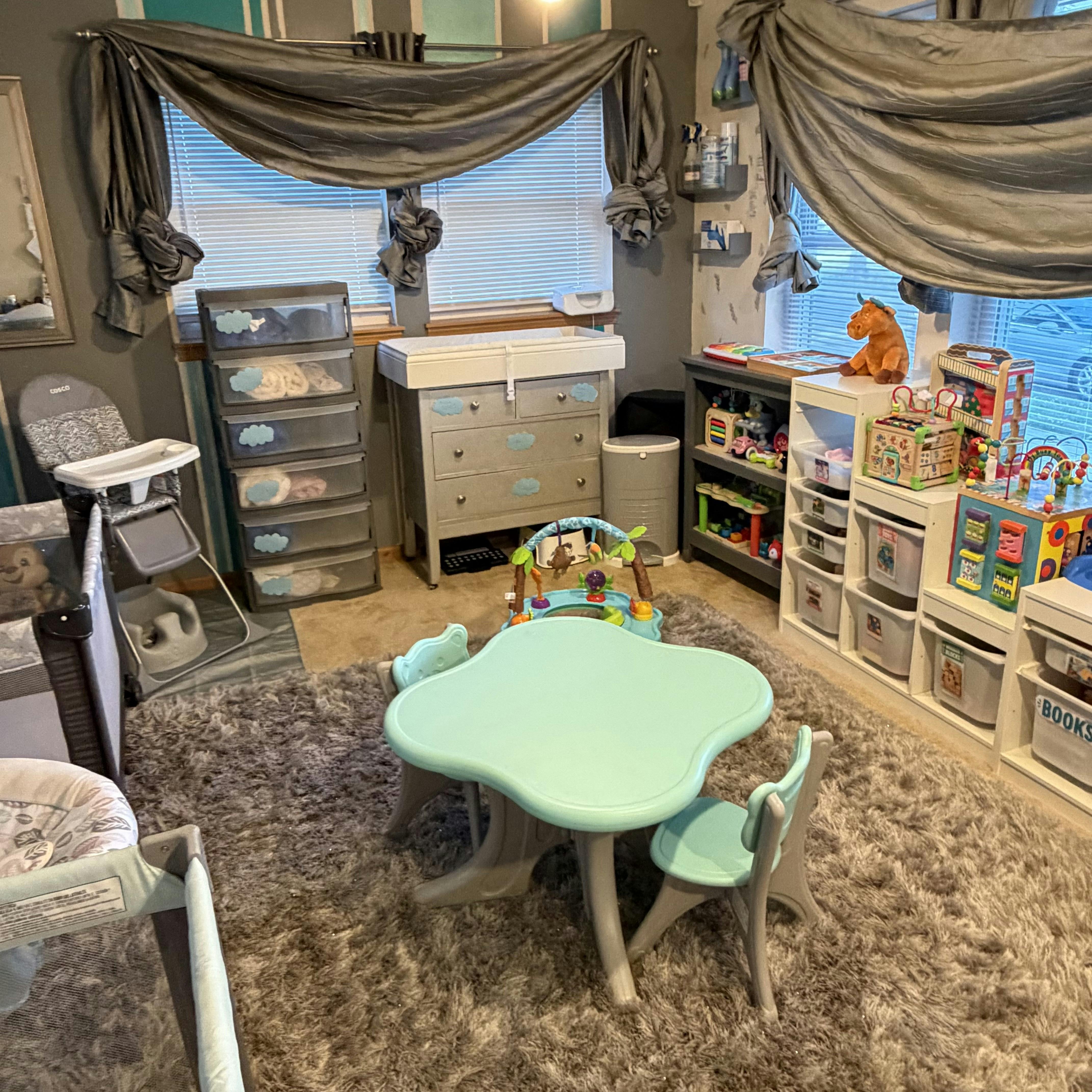 Child playroom with small table, chairs, storage units, and toy bins