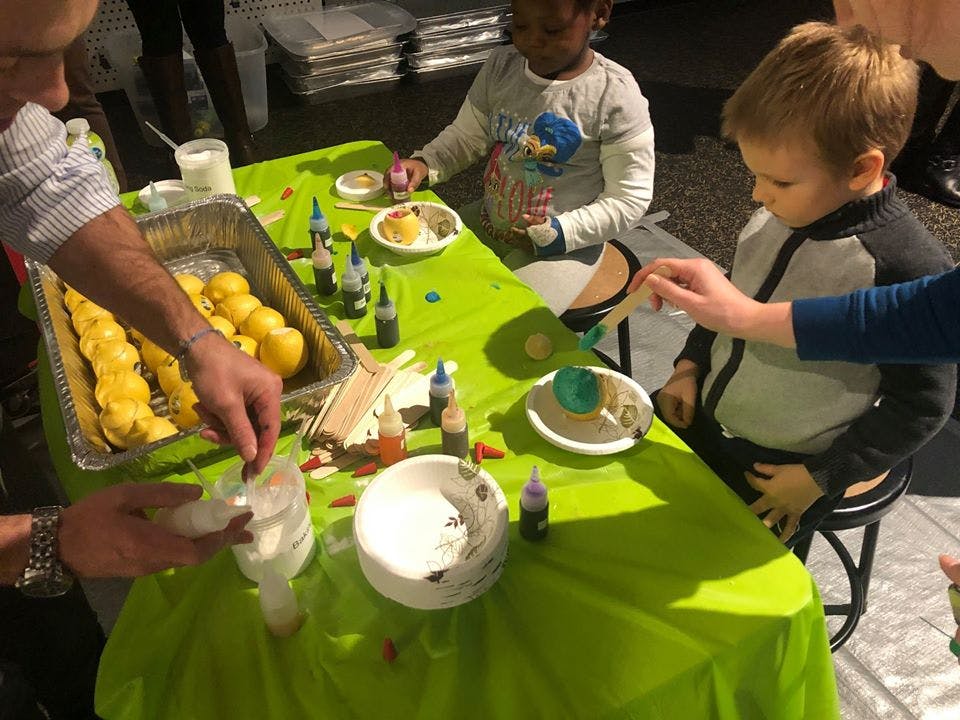 Person and two children decorating food at a table