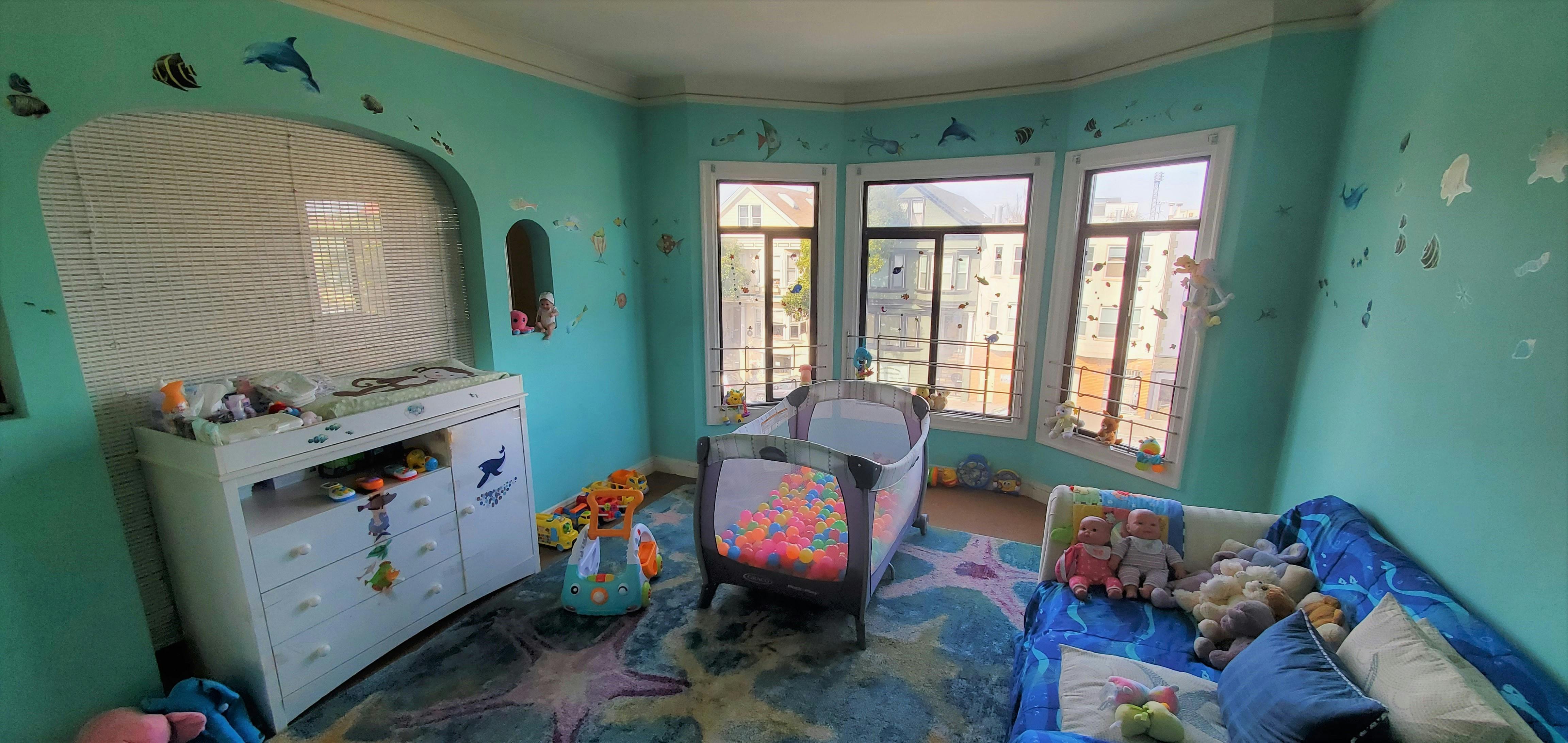 Nursery room with a crib, changing table, and windows