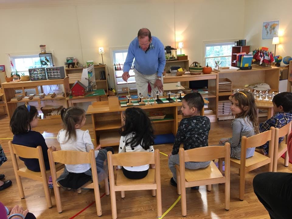 Adult person teaching a group of children in a classroom