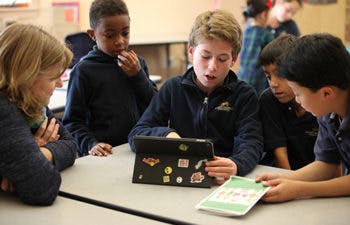 Children looking at a tablet in a classroom
