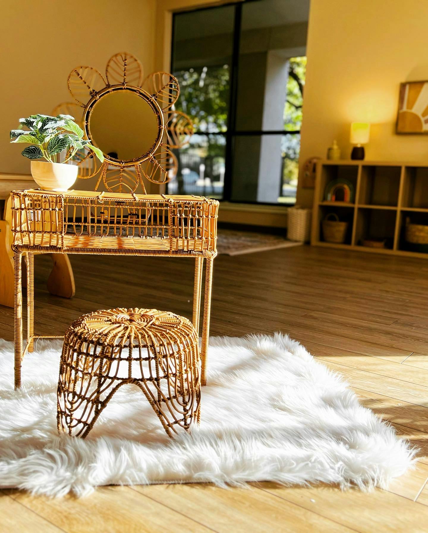 Rattan vanity with a mirror and stool on a white fluffy rug