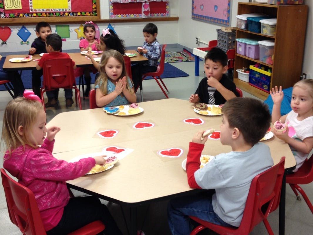 Children eating at tables in a classroom