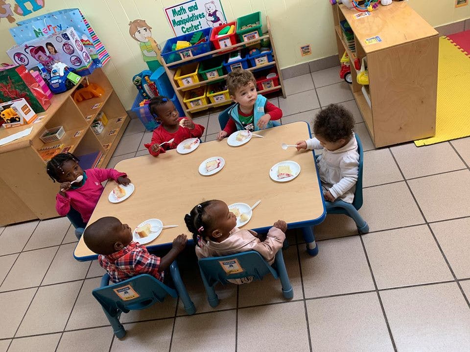 Children eating at a table in a classroom