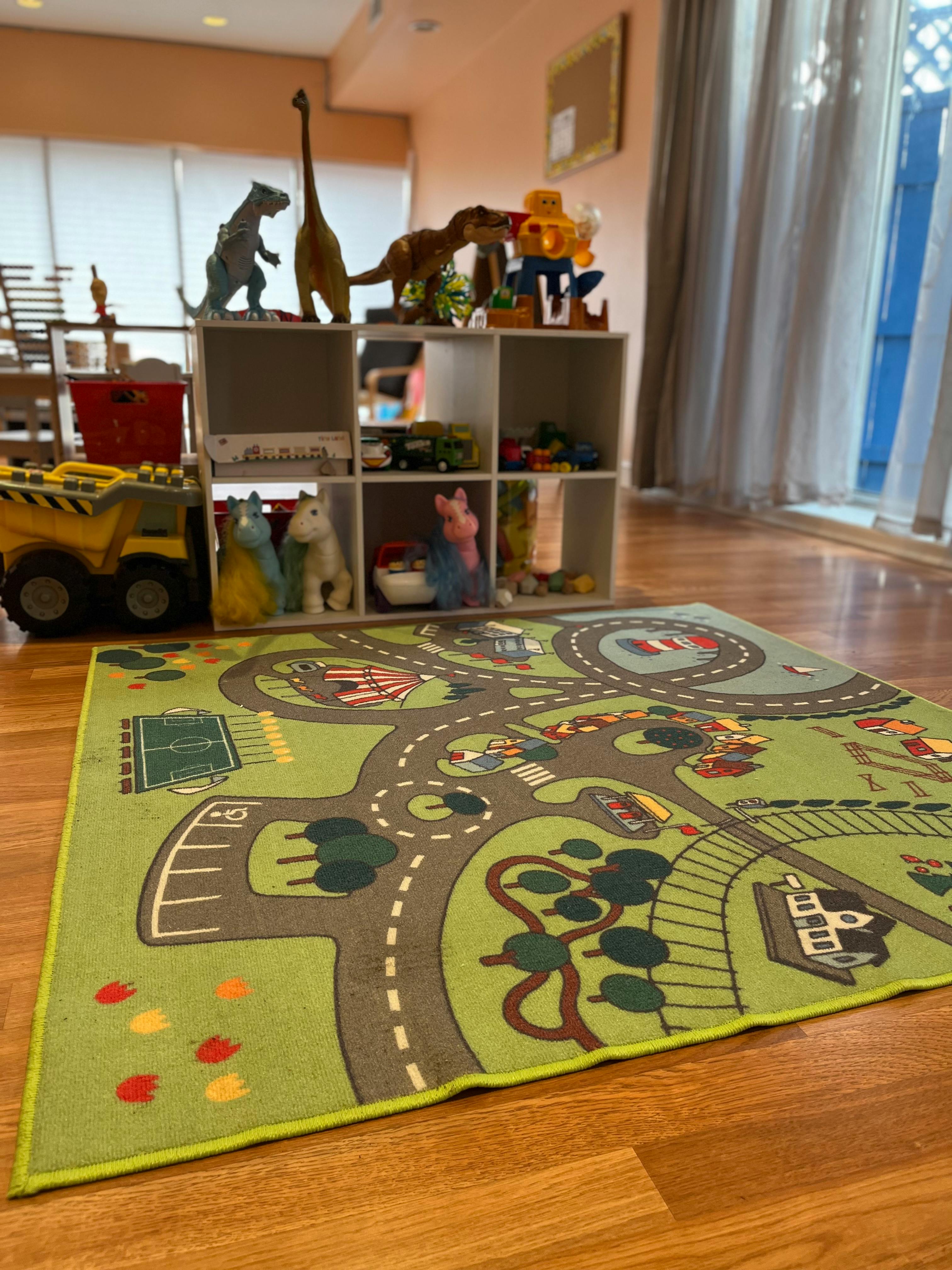 Playroom with a road map rug, toy shelf, and dinosaur figures