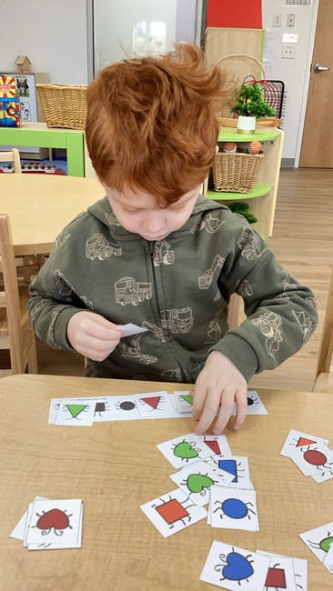 Child playing with cards on a table