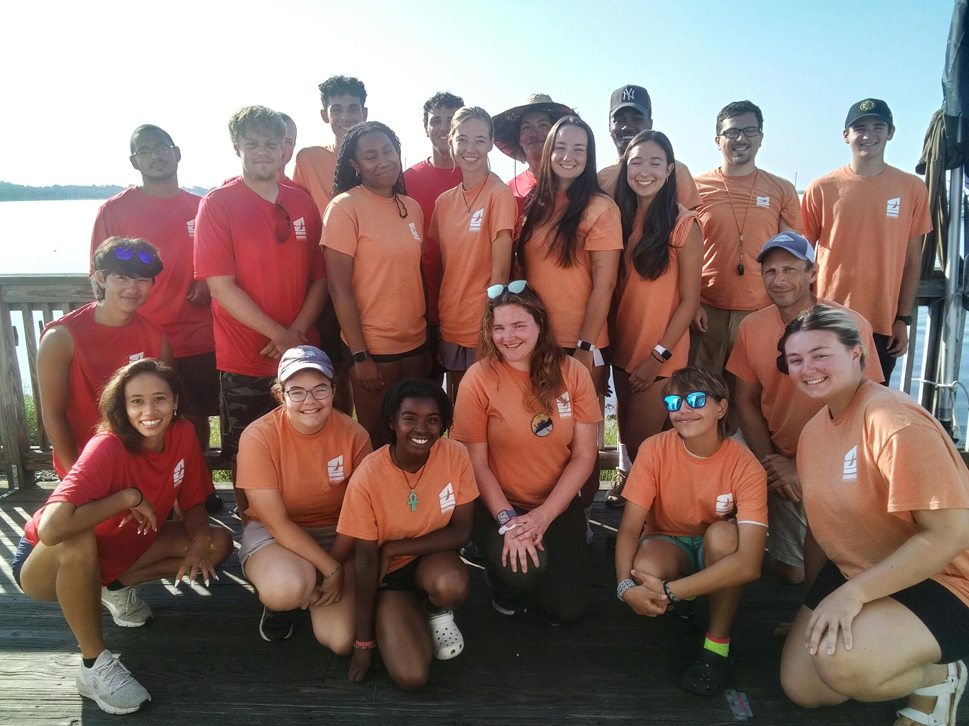 Group of people in orange and red shirts posing outdoors
