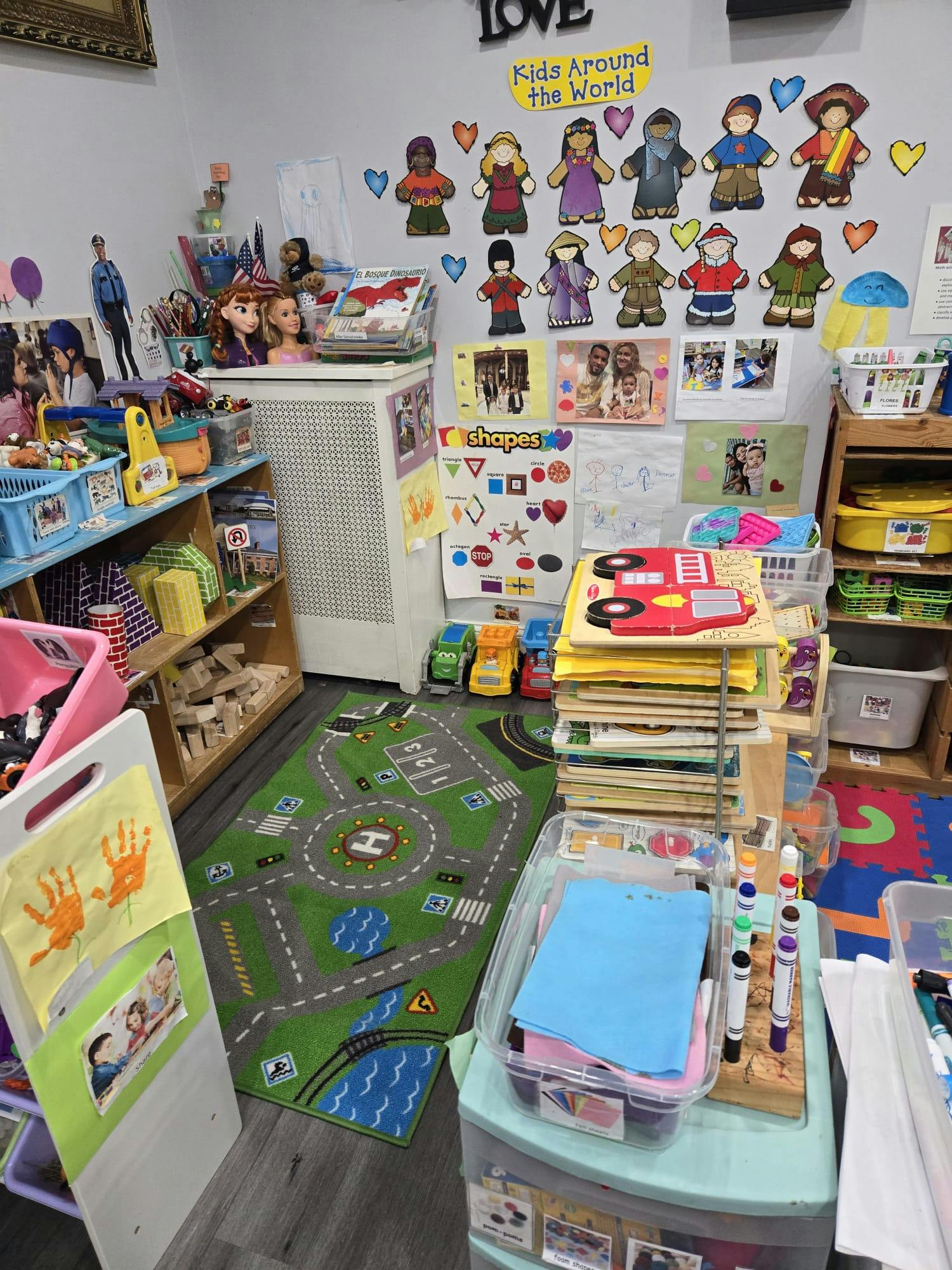 Children's play area with a road rug, puzzles, shelves of toys, and wall decorations