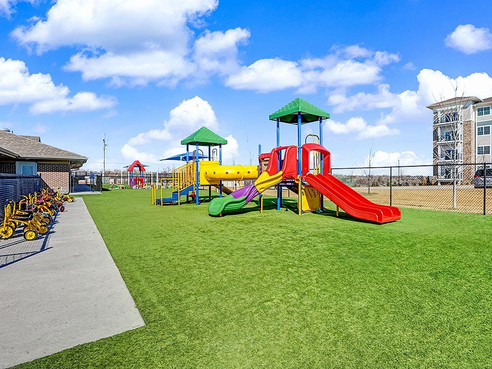 Colorful playground with slides, tunnels, and swings on green turf