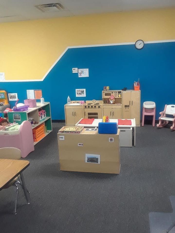 Playroom with toy kitchen, shelves, and small tables