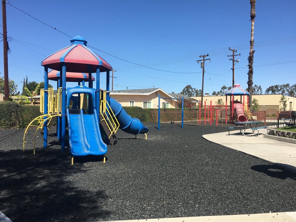 Playground with blue and red play structure and slides