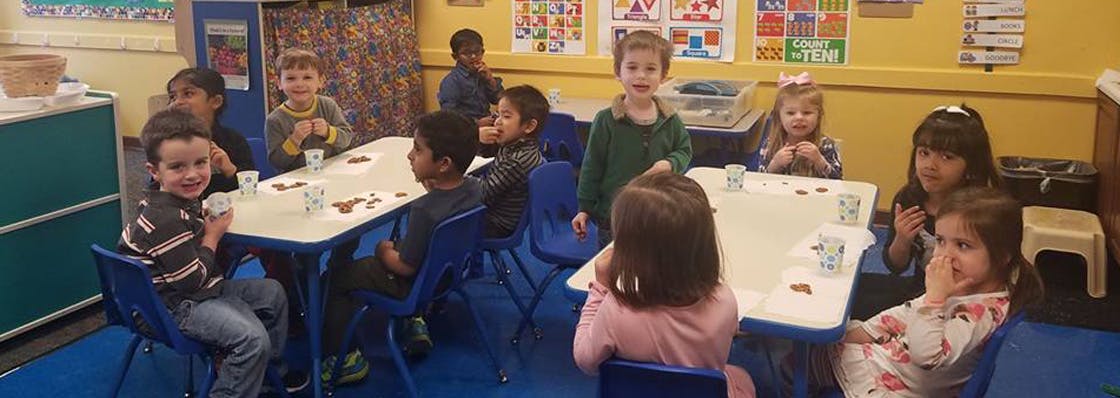 Group of children sitting at tables in a classroom