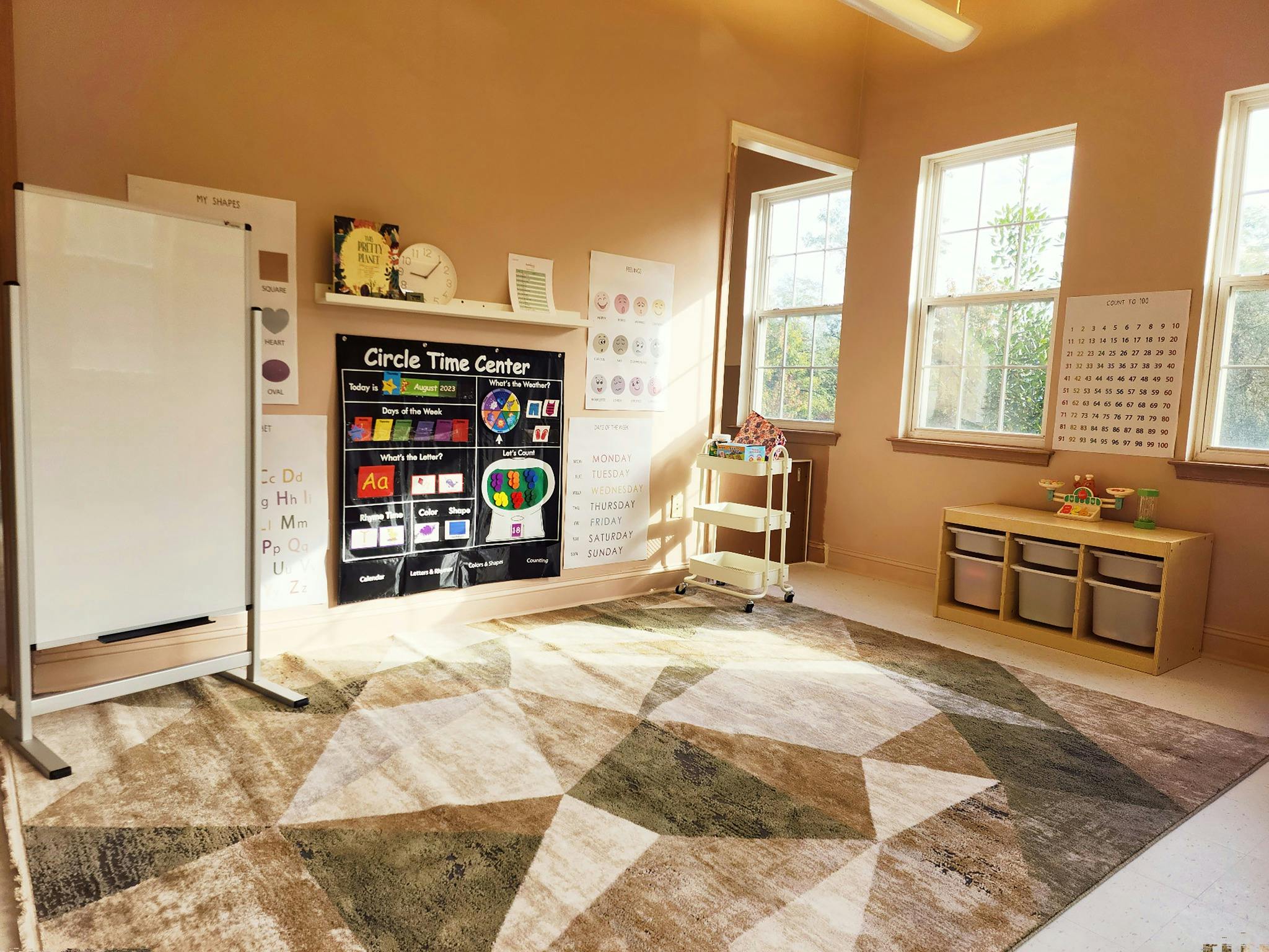 Classroom with a geometric rug, whiteboard, and "Circle Time Center" poster