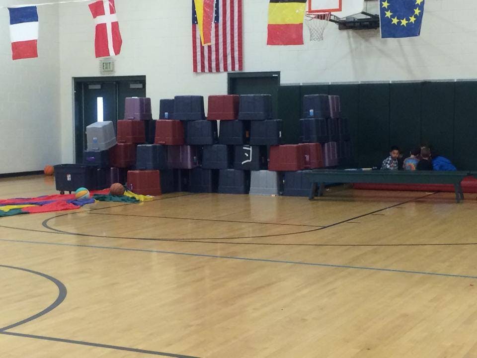 Stack of red and blue gym mats in a gymnasium