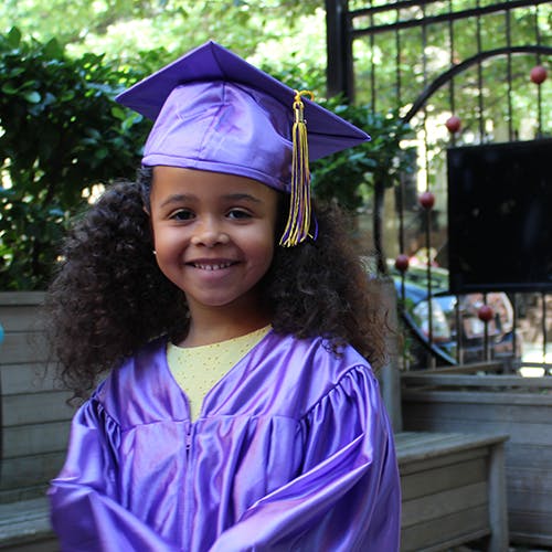 Child in a purple graduation cap and gown