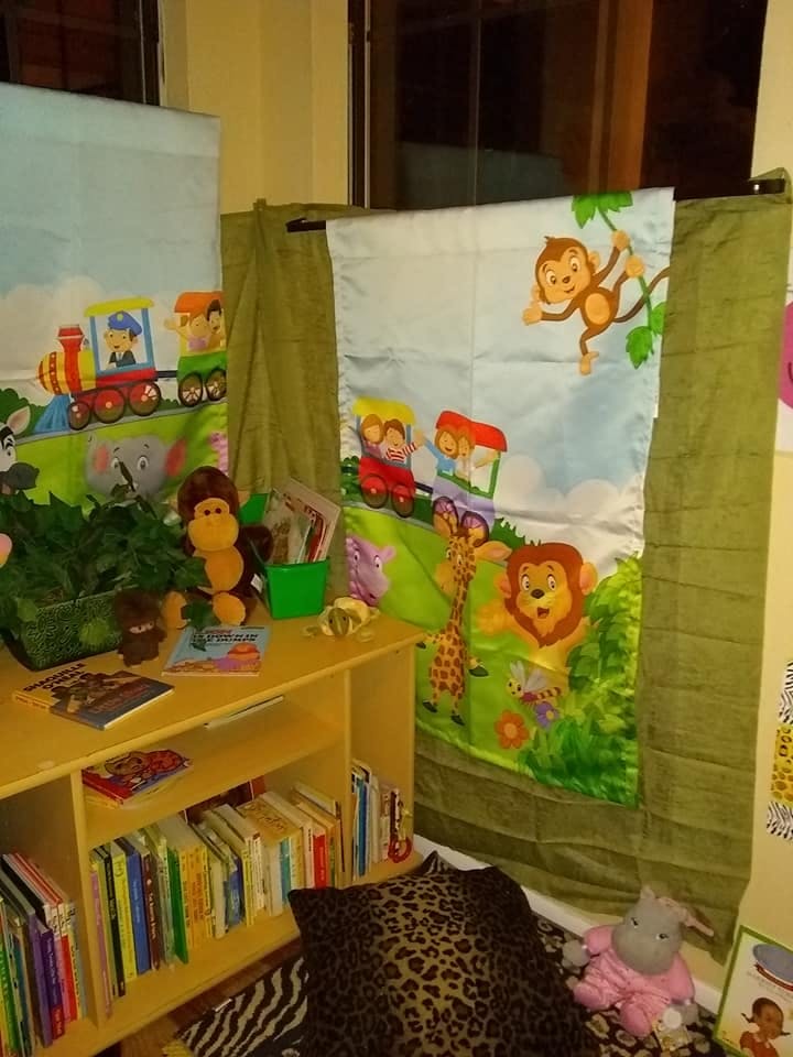 Children's bookshelf with books and safari-themed wall hangings