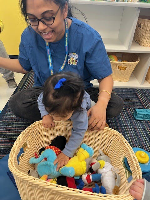 Person and child looking into a basket of stuffed animals