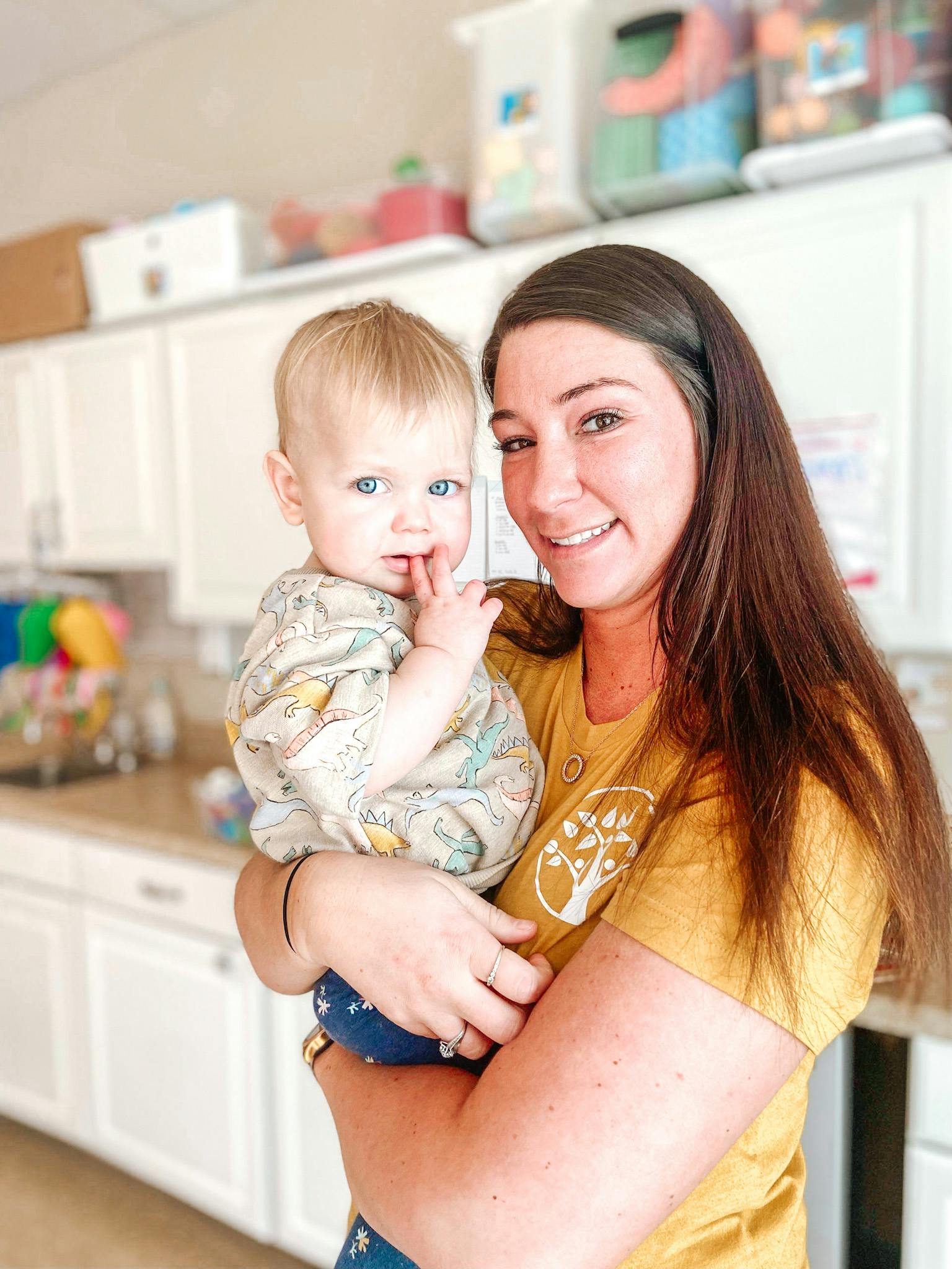 Person holding a child in a kitchen