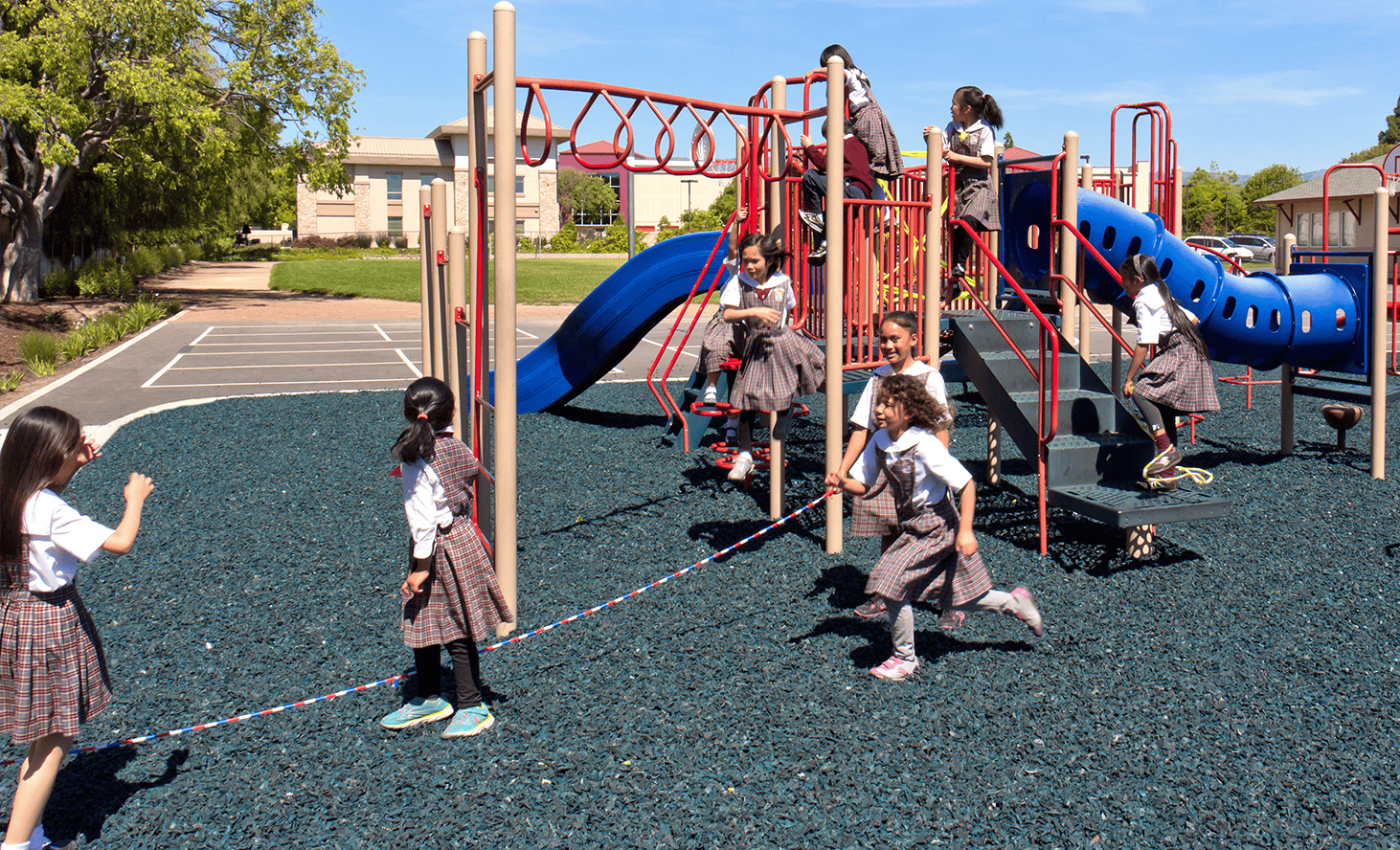 Children playing on a playground with slides and climbing structures
