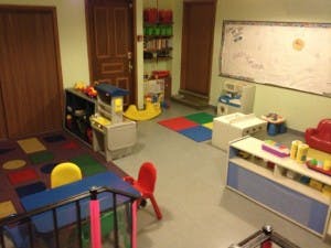 Playroom with colorful mats, small chairs, and toys