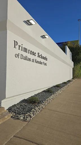 Primrose Schools of Dallas at Kessler Park sign on a white wall