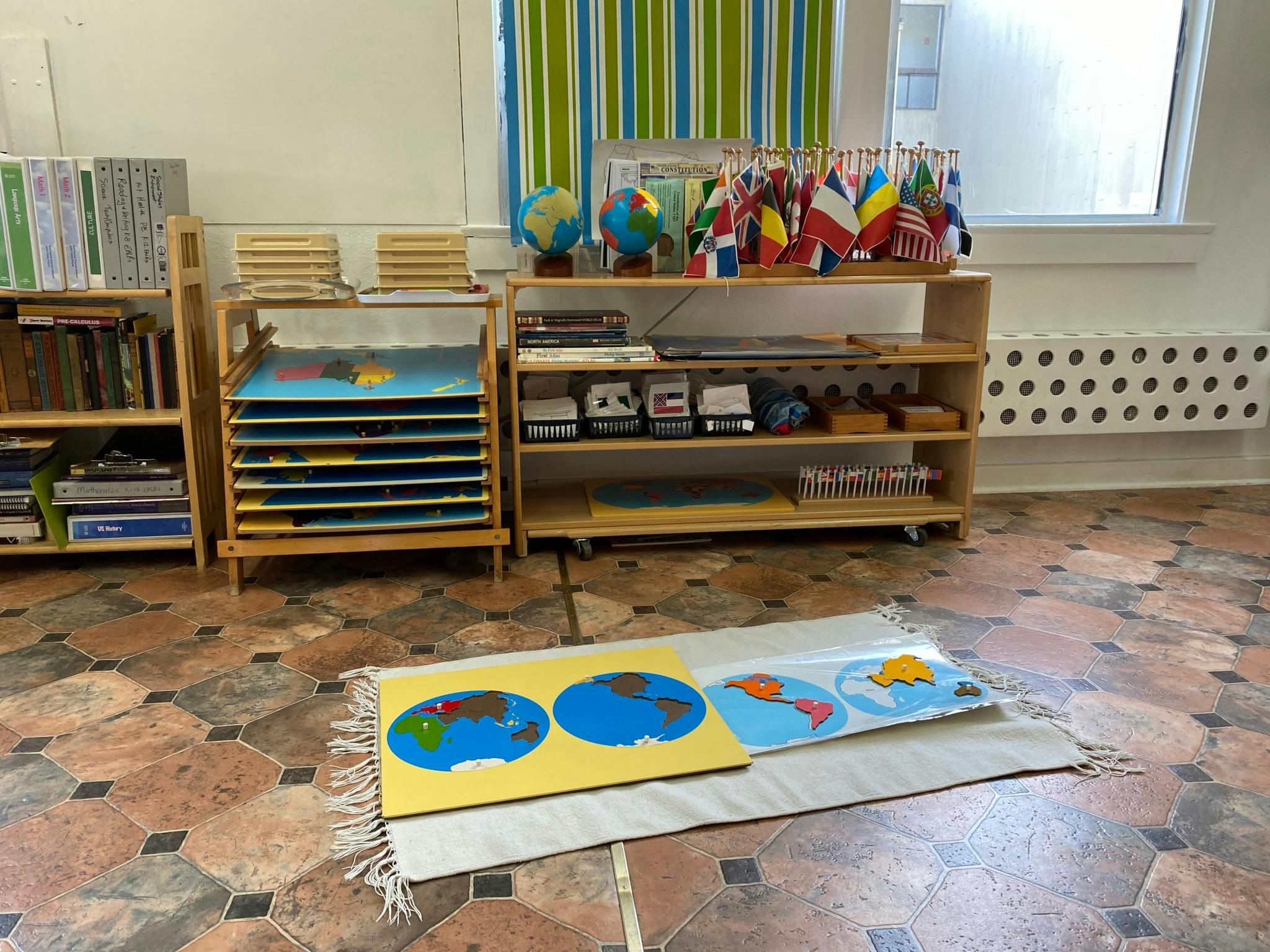 Montessori classroom with world map puzzles on a rug