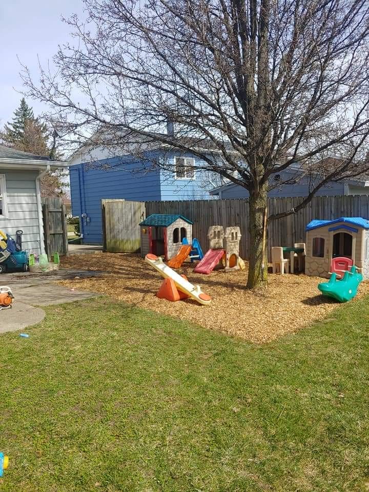 Backyard playground with playhouses, slides, and a seesaw