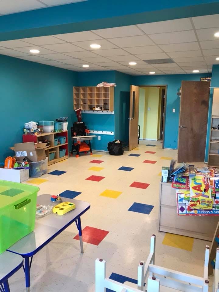 Empty classroom with colorful floor tiles and small tables