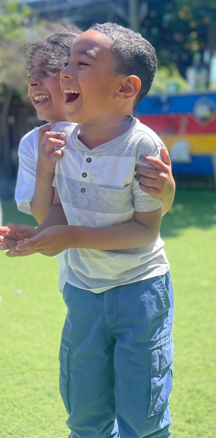 Two children laughing outdoors