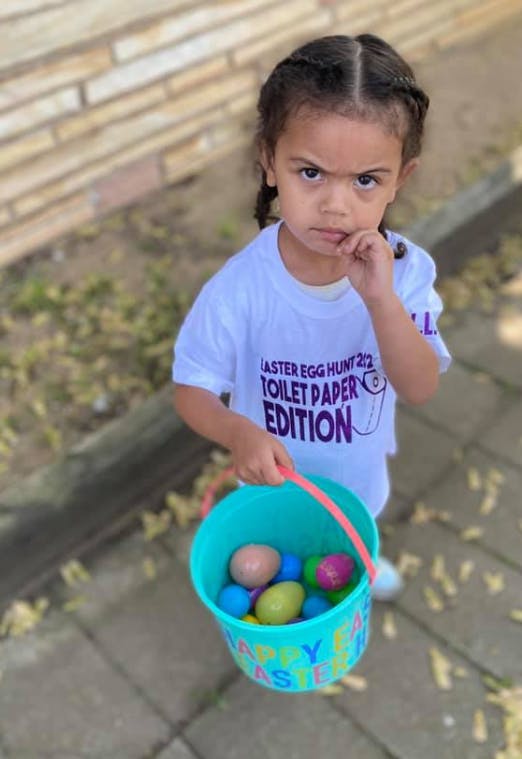 Child holding a bucket of colorful eggs