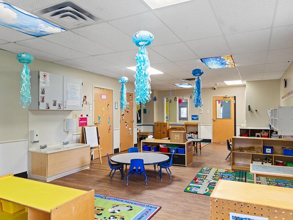 Classroom with child-sized furniture and jellyfish decorations hanging from the ceiling