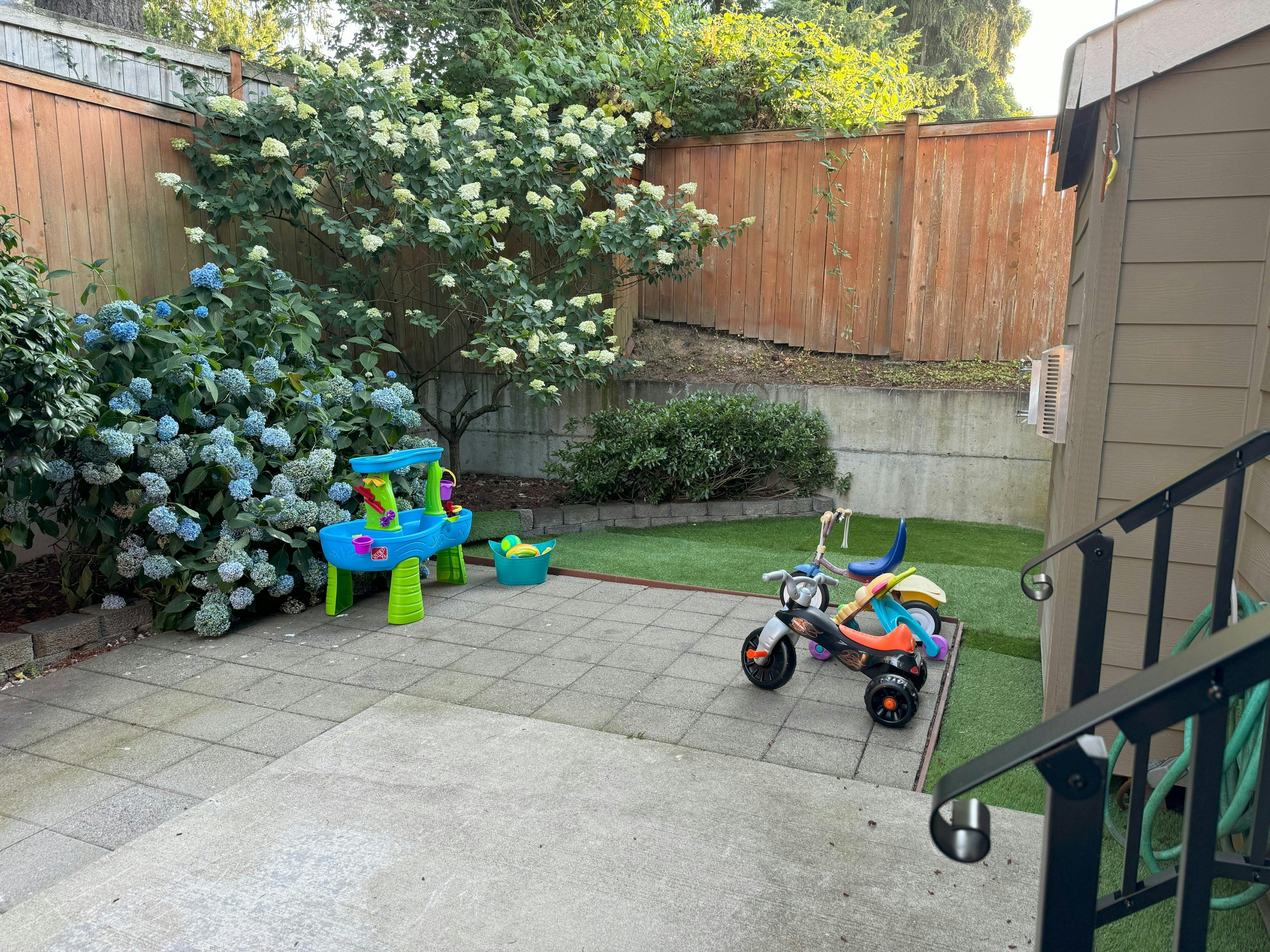 Patio with a child's water table and tricycle