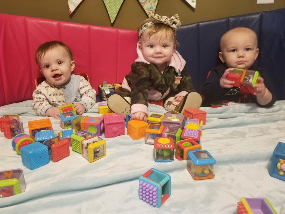 Three children playing with colorful blocks